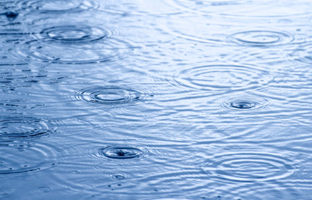 Water drops on the surface of the water. Blue color. Abstract background.の写真素材