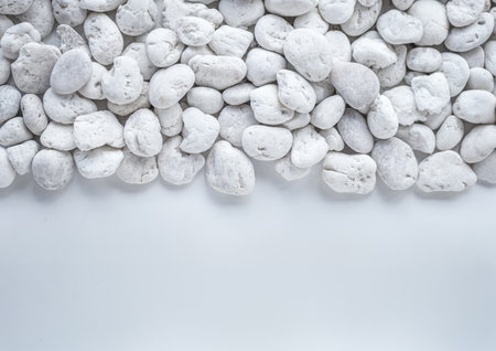 White pebbles on white background. Top view with copy spaceの写真素材