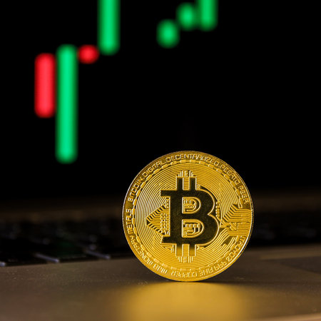 golden bitcoin on the background of a computer monitor with a graphの写真素材