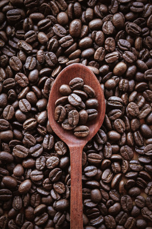 Coffee beans in wooden spoon on wooden background. Top view.の写真素材