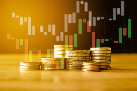 Stacks of coins with stock market graph and candlestick chart.の写真素材
