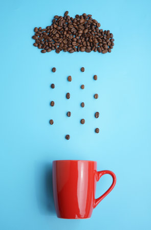 Coffee beans and red cup on blue background, top viewの写真素材