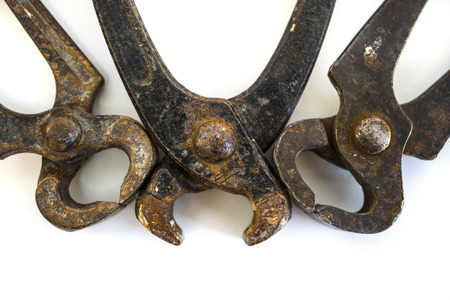 Close-up view of three rusty pincer pliers, one of them is with open tongs