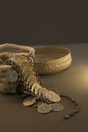 Wicker Basket With Handle And Spilled Coin Jewelry with chain and dark environmentの写真素材