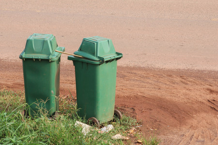 Green trash placed beside the road.の写真素材