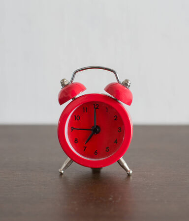 red  alarm clock on wooden floorの写真素材