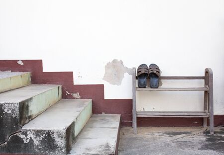 old leather slipper stand on woodden rack at foot of the stairsの写真素材