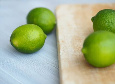 Whole limes closeup on wooden cutting boardの写真素材