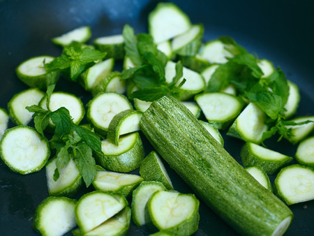 Cut raw zucchini in a frying pen ready to be cooked with mint as pasta sauce, selective focusの写真素材