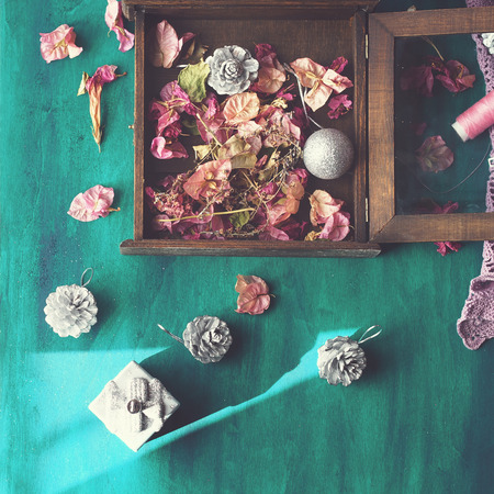 Christmas still life with christmas tree decorations and dried flowers on dark green wooden background, squareの写真素材