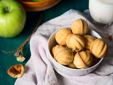 Still life on green wooden table with sandy pastry cookies, milk and applesの写真素材