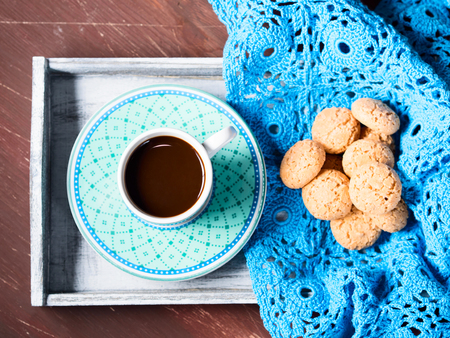 Cookies on a napkin and a cup of espresso coffee on a wooden trayの写真素材