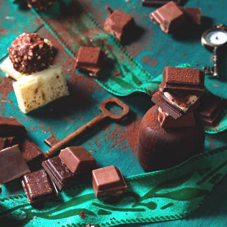 Dark and milk chocolate on green background - chocolate dark still lifeの写真素材