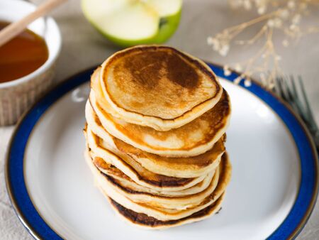 Breakfast with stacked yogurt pancakes on beige table clothの写真素材
