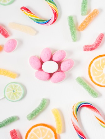 Fruit lollipops and candies on white canvas background, vertical imageの写真素材
