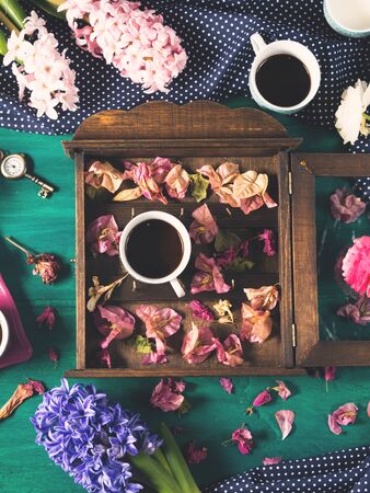 Cups of espresso coffee and flowers on dark green winter fall backgroundの写真素材