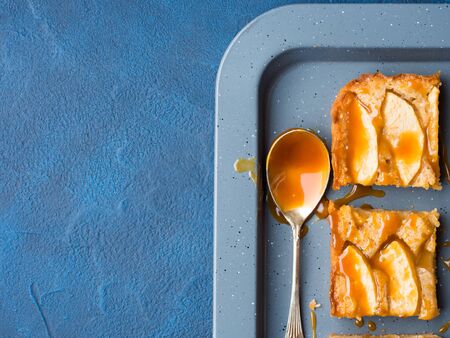 Home made apple cinnamon blondies with salted caramel. Sweet food home made dessert treat. Dark blue background flat layの写真素材