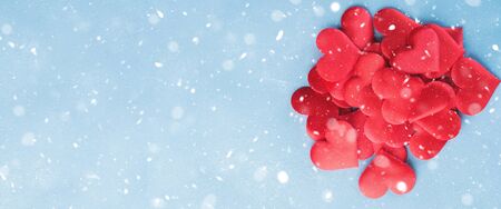 Valentines day banner with red hearts on light blue background. Falling snowの写真素材
