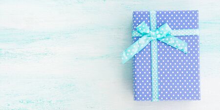 Blue gift box with ribbon on pastel background. Copy space top view fathers day Christmas special occasion presentの写真素材