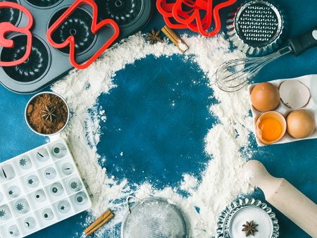 Flour frame Baking concept background on dark blue with tools accessories and sweet food cake cookie pie ingredients sugar, eggs, cocoa, cinnamon. Top view flat lay making dough conceptの写真素材