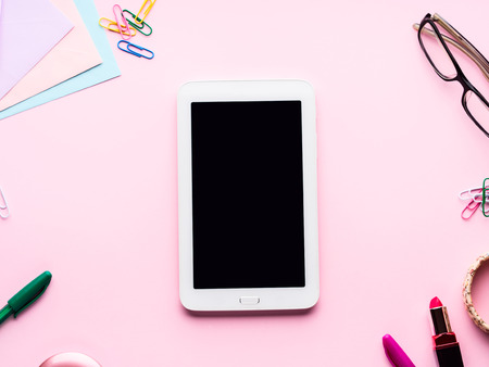 Pink pastel flat lay with gadget tablet smartphone stationery glasses woman lipstick, braceletsの写真素材