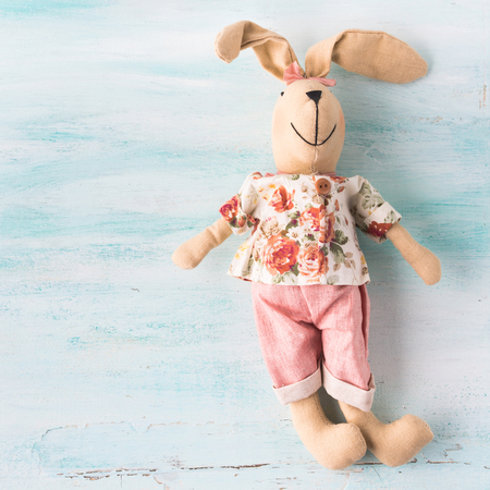 Easter bunny doll over turquoise pastel wooden background. Holiday greeting cardの写真素材