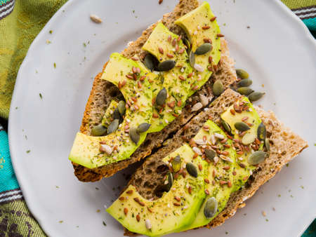 Avocado cereal sandwich for healthy snack with seeds on green napkinの写真素材