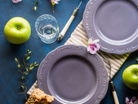 Empty gray plates served for lunch with flowers and herbs. Spring summer healthy meal conceptの写真素材