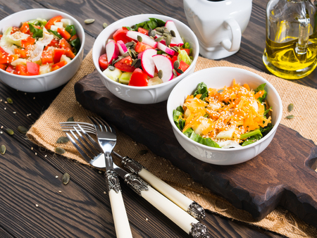 Colorful vegetable salad bowl for lunch on wooden rustic backgroundの写真素材