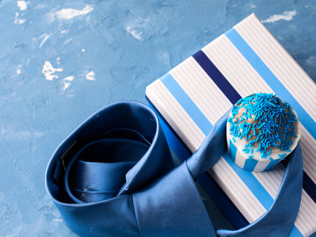 Father's day card with gift box and cup cake, tie on blue backgroundの写真素材