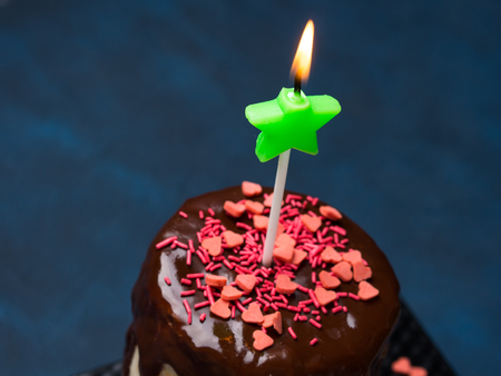 Cream cheese sponge cake with chocolate glaze and pink heart sprinkles on dark blue background. Birthday party Valentine mother day treatの写真素材
