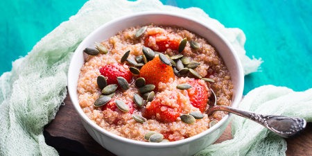 Quinoa porridge with strawberries and pumpkin seeds in bowl. Light dairy and gluten free breakfastの写真素材