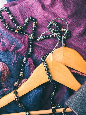 Wooden clothes hangers and lady's accessories. What to wear in autumn winter concept. Woman clothingの写真素材