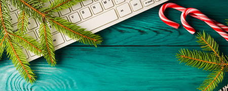Winter christmas green background with green fir tree branch and keyboardの写真素材
