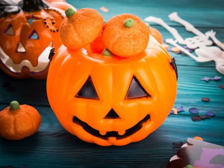 Halloween trick or treat still life on dark green. Toy pumpkin, sweets, marshmalllow, confetti. Holiday mood backgroundの写真素材