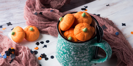 Mug of hot chocolate with Pumpkin shaped halloween marshmallows with holiday decorations. Children partyの写真素材