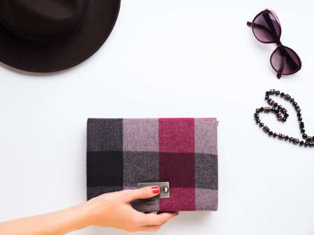 Flat lay with lady's hat, sun glasses necklace and clutch. Autumn colours accessories clothes on white background. Woman's handの写真素材