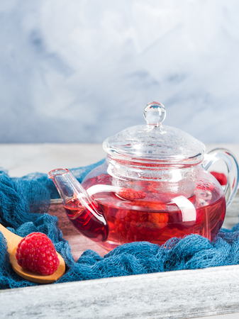 Raspberry tea in glass teapot on gray. Healthy hot drinkの写真素材