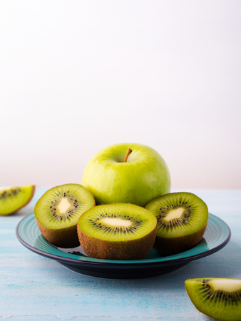 Green apples and kiwi on turquoise backgroundの写真素材