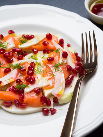 Salad with fennel, salmon and pomegranate, olive oil and pomegranate juiceの写真素材