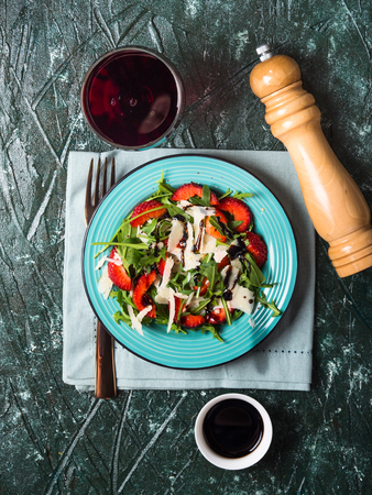 Salad with strawberries, arugula and parmesan drizzled with balsamic glazeの写真素材