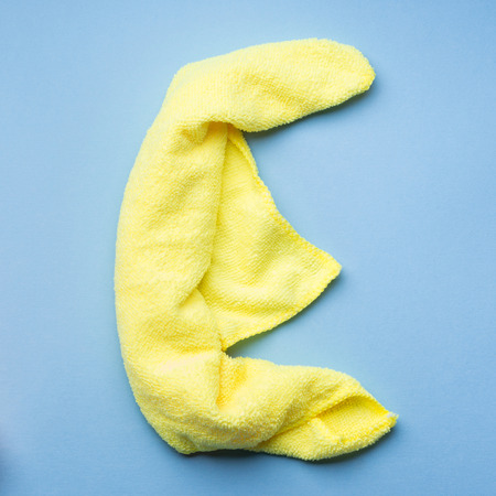 Letter E made with cleaning cloth on blue background. Part of word Clean