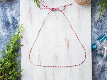 Christmas flat lay background with twine bell frame on white wooden board.の写真素材
