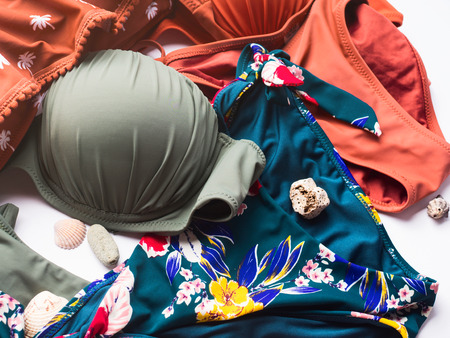 Womans swimsuits on white background with sea summer stones and shellsの写真素材