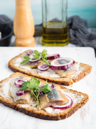 Danish open sandwich smorrebrod with salted herrings, red onion, butter. Traditional snackの写真素材