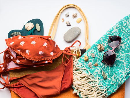 Beach female fashion accessories swimsuit, sun glasses, hat, flip flops, towel and bag. Summer traveling holiday concept flat layの写真素材