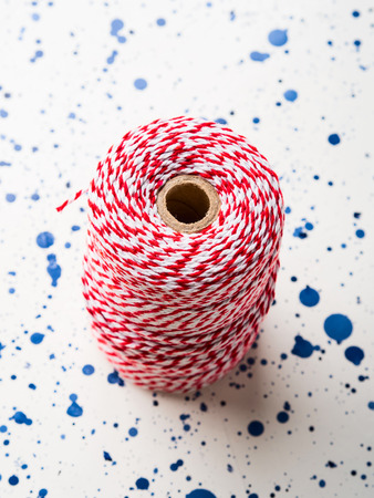 Red twine string roll on white background. Accessory for wrapping gifts