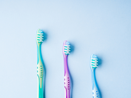 Plastic toothbrushes on blue. Dental hygiene concept backgroundの写真素材
