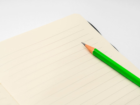 Blank page of lined notebook with green pencilの写真素材