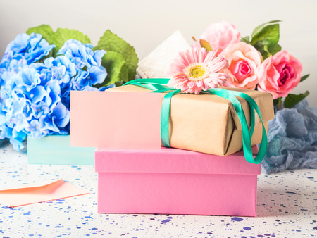 Blank pink card and stacked gift boxes. Flowers. Woman, mother, Valentine day greeting card. Copy spaceの写真素材